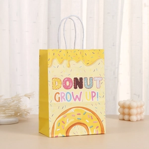 Yellow 'Donut Grow Up' kraft paper gift bag with white rope handles and donut print