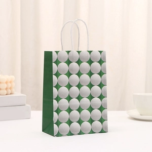 Detalle de bolsa de regalo de papel verde con patrones de golf y asas blancas
