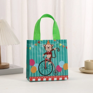 Close-up of non-woven gift bag with monkey on bicycle and colorful party flags