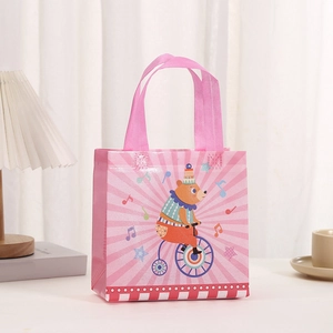 Close-up of pink non-woven gift bag with circus bear pattern in a cozy home setting