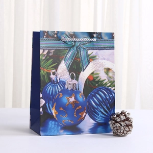 Navy blue Christmas gift bag with festive ornaments, pine branch print and silver handles