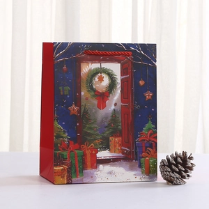 Red Christmas paper gift bag with festive wreath and tree illustration and red handles