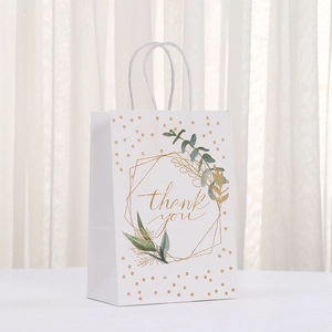 White kraft paper gift bag with gold thank you print and green leaf patterns