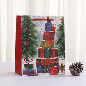 Detail of red Christmas gift bag with festive tree print and sturdy rope handle