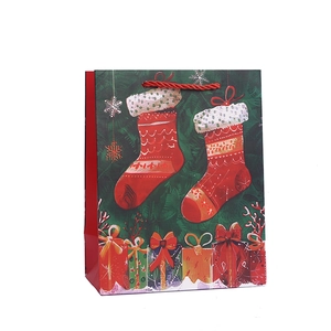 Christmas gift bag with green base, festive stocking and gift box patterns on white paper