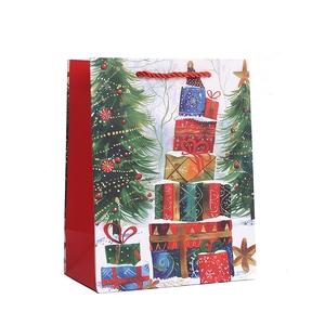 Christmas gift bag with festive trees and red handles on white cardboard background