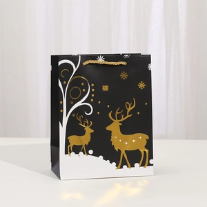 Vertical black paper gift bag with golden reindeer and snowflake prints for Christmas