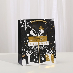 Black Christmas gift bag with gold reindeer and snowflake patterns and golden handles