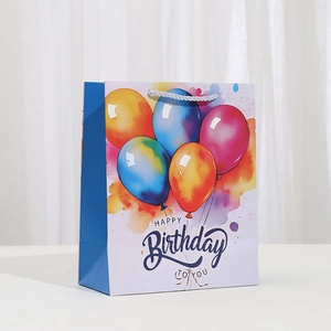Detail of cartoon birthday gift bag with colorful balloon prints and woven handles