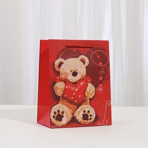 Sac cadeau en papier kraft rouge avec motif ours en peluche et poignées cordées