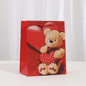 Détail du sac cadeau rouge en papier kraft avec ours en peluche et poignées