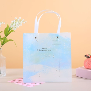 Bolsa de regalo degradada azul y blanca con asas de cinta y texto artístico motivador