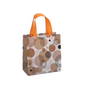 Waterproof non-woven tote bag with abstract circular patterns and bright orange handles