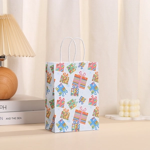 Détail d'un sac cadeau en papier bleu clair avec motifs de boîtes et poignées en corde