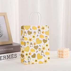 Geschenktüte aus Kraftpapier mit Bienen-Motiv und stabilen weißen Kordelgriffen