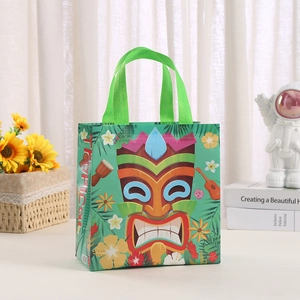 Detail of tropical non-woven gift bag with Tiki mask print and green handle