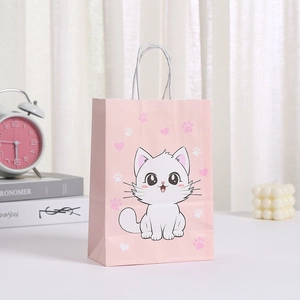 Detalle de bolsa de regalo rosa con estampado de gato y asas de papel blanco trenzado