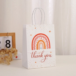 Detail of bohemian rainbow paper gift bag with white rope handle and thank you text