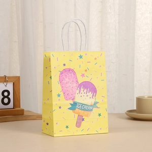 Detalle de bolsa de regalo kraft amarilla con diseño de helado y asas de cuerda blanca