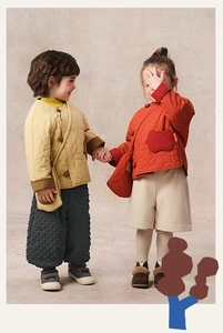 Detailed view of quilted winter jackets with traditional buttons and warm trousers for girls
