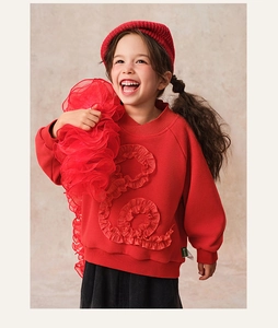 Detail of red festive sweatshirt with decorative S-shaped ruffle and ribbed neckline