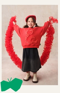 Detail of red festive sweatshirt with 3D ruffle texture and gradient denim skirt
