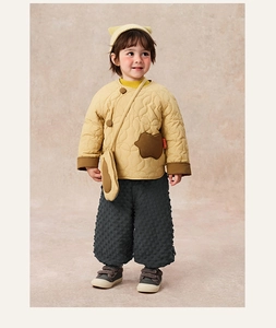 Detailed view of yellow quilted winter coat with bear pockets and grey bubble texture pants