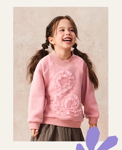 Detail of pink fleece sweatshirt featuring traditional knot buttons and S-shaped ruffles