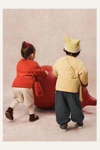 Detail view of quilted winter jackets for kids with traditional buttons and soft textures