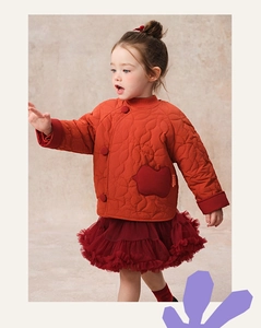 Detail of girl's red quilted winter jacket with apple pockets and mesh tutu skirt