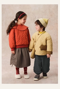 Detailed quilting on traditional winter padded coats for children in vibrant warm colors