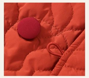Detail of traditional Chinese frog button on red quilted winter coat for girls