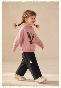 Detail of pink toddler sweatshirt featuring a cute bunny print and black wide-leg pants