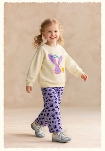 Detail of girls' cream sweatshirt with purple bunny print and matching polka dot trousers
