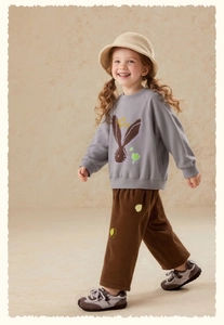 Detail of grey girl's sweatshirt with bunny print and brown corduroy trousers outfit
