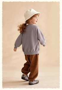 Detail view of child's casual grey sweatshirt and brown corduroy pants for autumn