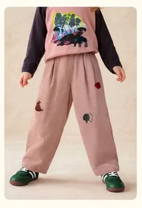 Close-up of children's corduroy trousers with detailed embroidery and soft fabric texture