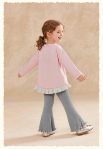 Détail du sweat rose fille avec volants à pois et pantalon évasé à rayures grises