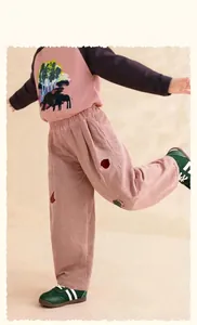 Detail of pink corduroy pants for kids with elastic waist and knee embroidery