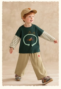 Detail von Jungen grünem Lagen-Langarmshirt mit 3D-Katzenmotiv und khakifarbenen Cordhosen