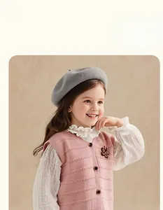 Pink knit sweater vest with delicate embroidery details and ruffled white shirt collar