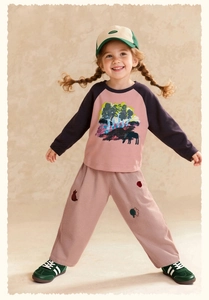 Detailed view of children's pink raglan top and corduroy pants with animal embroidery