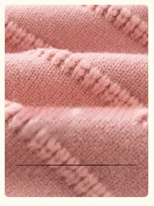 Macro shot of pink cable knit fabric texture showing soft wool and butterfly details