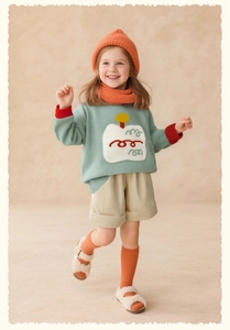 Detailed view of mint green knit sweater paired with beige corduroy cuffed shorts for girls