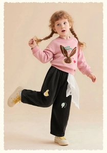 Detail of pink sweatshirt with bunny print and black corduroy pants with lace splicing