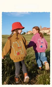 Detail of knitted kids baseball jacket featuring pixelated cartoon cat embroidery on the back