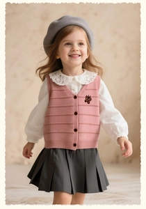 Detail of girls pink knit vest with bow embroidery and lace collar white shirt