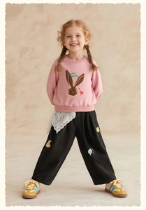 Detail of pink sweatshirt with bunny print and black corduroy trousers for kids