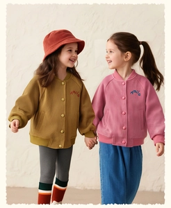 Detail of girls' corduroy baseball jackets with embroidered letters and button closure