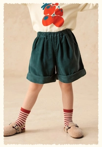 Detail view of dark green corduroy shorts for girls with elastic waist and rolled hem